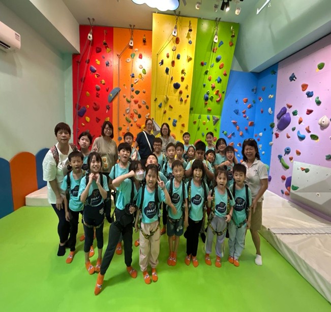 Children and adults together in front of colourful indoor climbing walls
